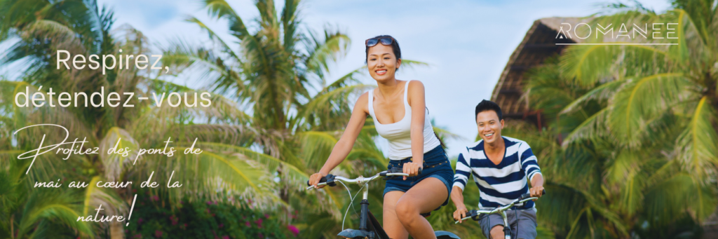 Couple fait du vélo entre palmiers en vacances.