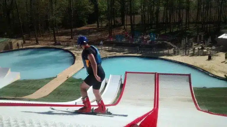 Ski nautique sur rampe, piscine derrière.